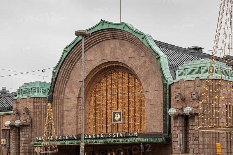 Torchbearers flank main entrance, statues of Emil Wikström, Central Station with Christmas decoration, Helsinki, Finland