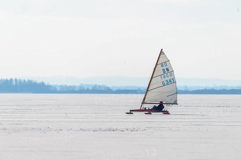 Ice sailor glides over icy surface under clear sky in wintry landscape, Lembruch, Diepholz district, Lower Saxony, Germany