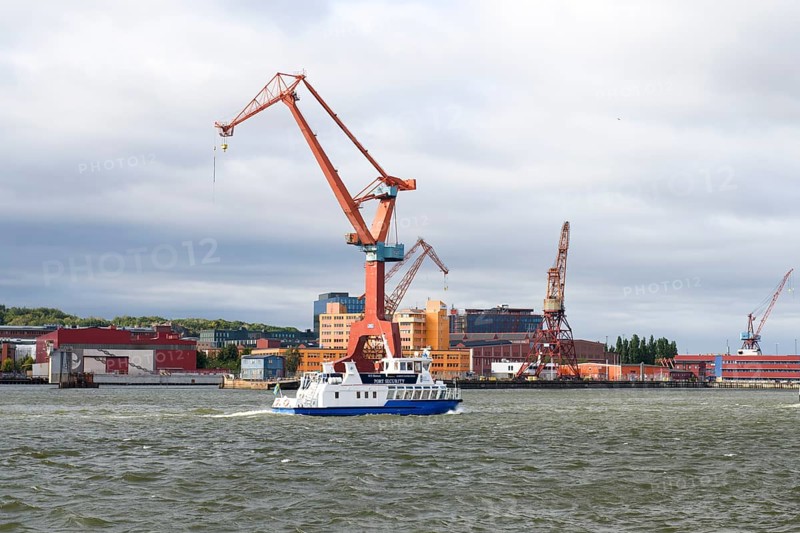 Large industrial port crane and ship on water under cloudy sky in Gothenburg harbour, Gothenburg, Västra Götalands län, Sweden