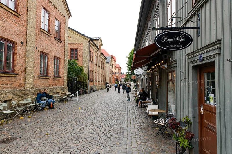 Lively street scene with cafés and historic buildings along a cobblestone street in Gothenburg's Haga district, Gothenburg, Västra Götalands län, Sweden