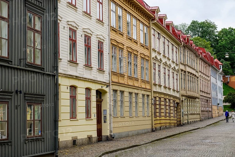 A series of colorful old buildings with decorated facades along a cobblestone street in the Haga district of Gothenburg, Västra Götalands län, Sweden