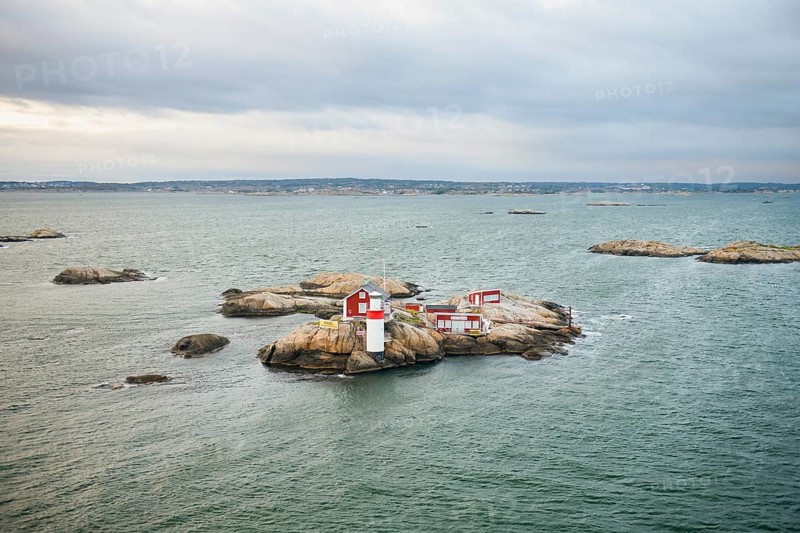 Small rocky island with lighthouse and red buildings in the calm sea, near Gothenburg, Västra Götalands län, Sweden