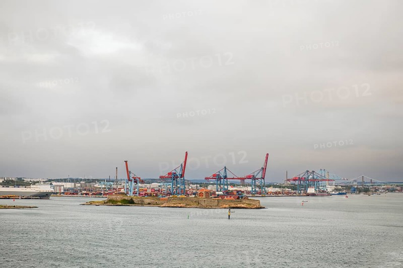 View of container bridges in Gothenburg harbour with cranes and water in the foreground under grey sky, Gothenburg, Västra Götalands län, Sweden