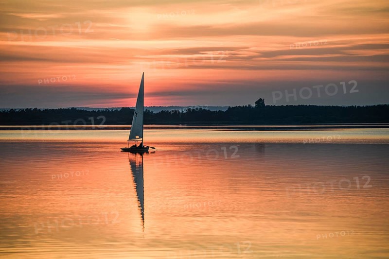 Single laser dinghy sailboat on quiet Dümmer See at vivid sunset, Lembruch, Dümmer See, Lower Saxony, Germany