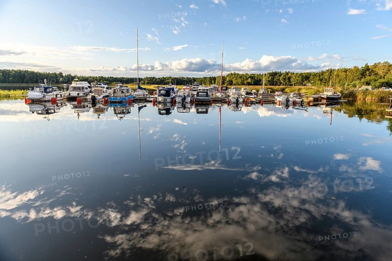 Several boats are moored in the quiet pleasure boat harbor of Ekenäs, water reflects the sky, Ekenäs, Värmlandsnäs peninsula, Värmlands län, Sweden