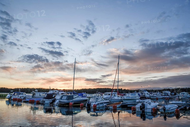Boats in sports boat harbor at sunset with dramatic clouds, Ekenäs, Värmlandsnäs peninsula, Värmlands län, Sweden