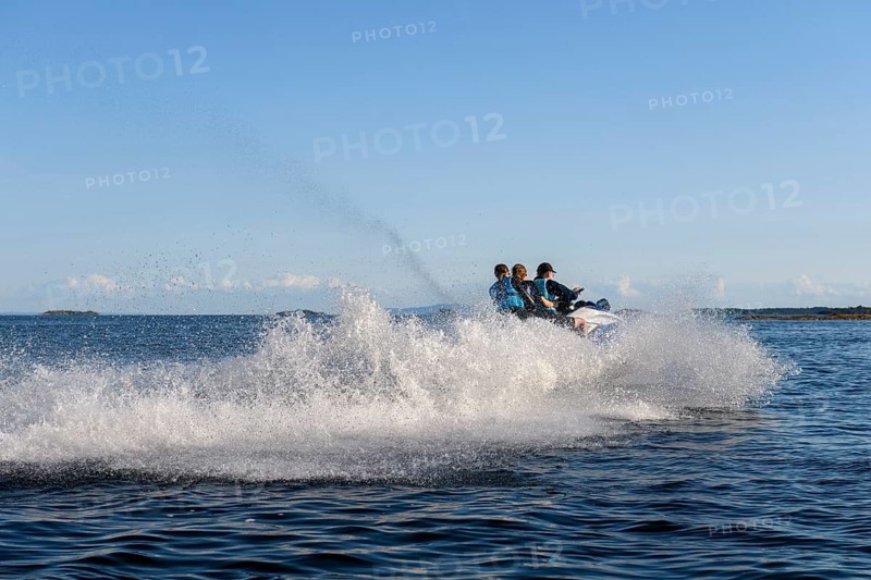 People ride fast across Lake Vänern on a jet ski and generate waves, Värmlandsnäs peninsula, Värmlands län, Sweden