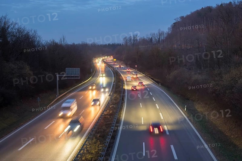 Night view of a motorway trip in the dark, surrounded by forest and vehicle lights, near Stuttgart, Baden-Württemberg, Germany