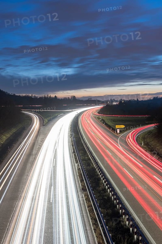 Long-exposure view of a motorway at night with continuous light trails on a blue sky, near Stuttgart, Baden-Württemberg, Germany