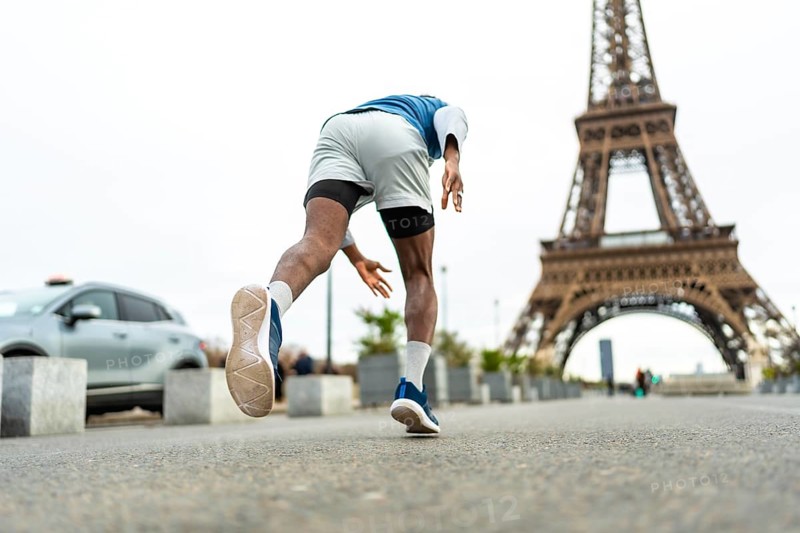 Athlete training outdoors in urban paris, enjoying fitness and an active lifestyle while jogging with the iconic eiffel tower in the background, symbolizing sport and travel