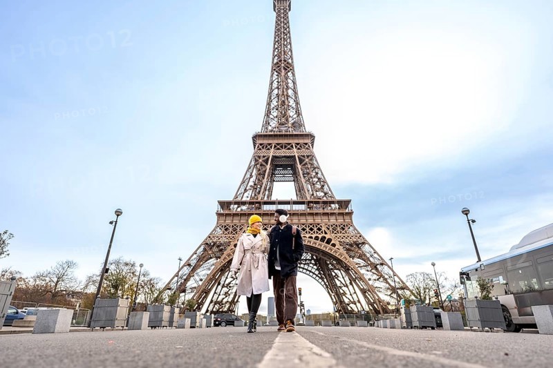 Young happy couple walking hand in hand during their city trip through paris, exploring the iconic eiffel tower and experiencing romance and international travel together
