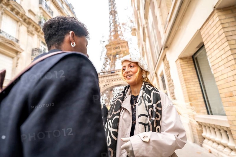 Happy couple happily conversing on a picturesque paris street with the iconic eiffel tower in the background, embodying travel, romance, and an urban adventure