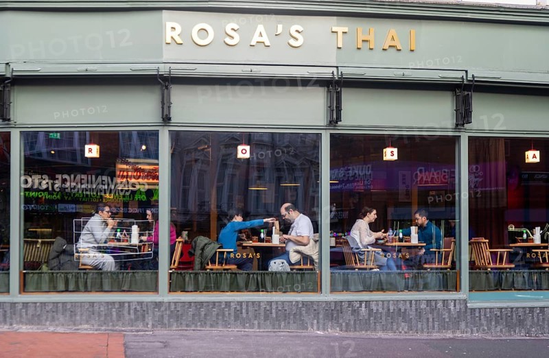 People eating at tables inside Rosa's Thai restaurant, Kings Road, Reading, Berkshire, England, UK