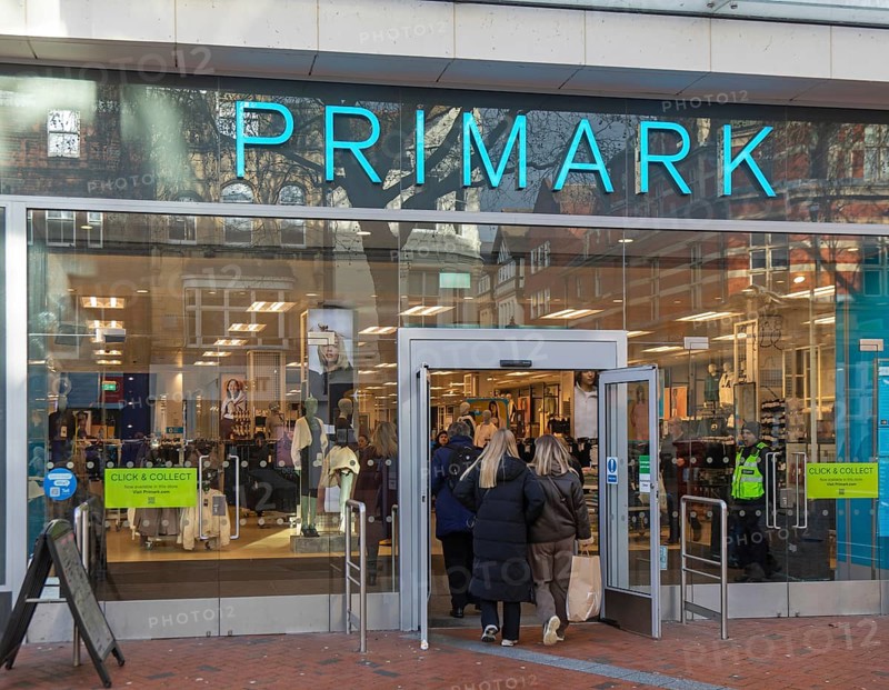 Shoppers entering through doorway entrance of Primark shop in town centre of Reading, Berkshire, England, UK