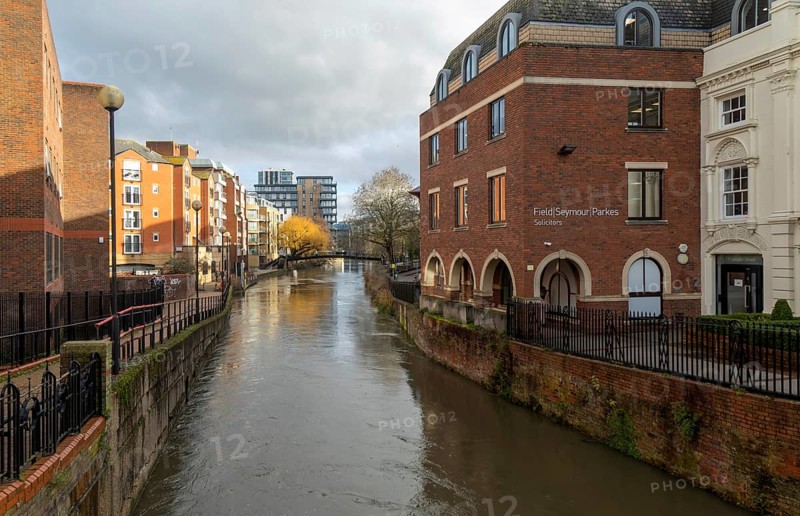 River Kennet flowing past apartment housing and businesses, view east from London Street, Reading, Berkshire, England, UK