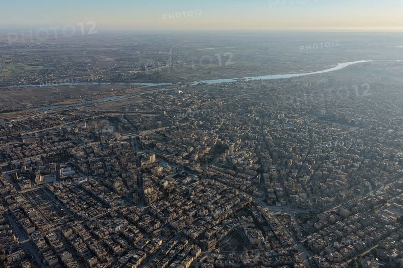 In Deir ez-Zor, Eastern Syria on January 21, 2026, an aerial drone shot captures the city landscape after Syrian Government forces successfully secured control. The deployment follows the withdrawal of SDF (Syrian Democratic Forces) elements as part of the broader strategic shifts and integration agreements in the region. The footage shows the city's infrastructure and the Euphrates River under the new military administration, Deir ez-Zor, Deir ez-Zor, Syria