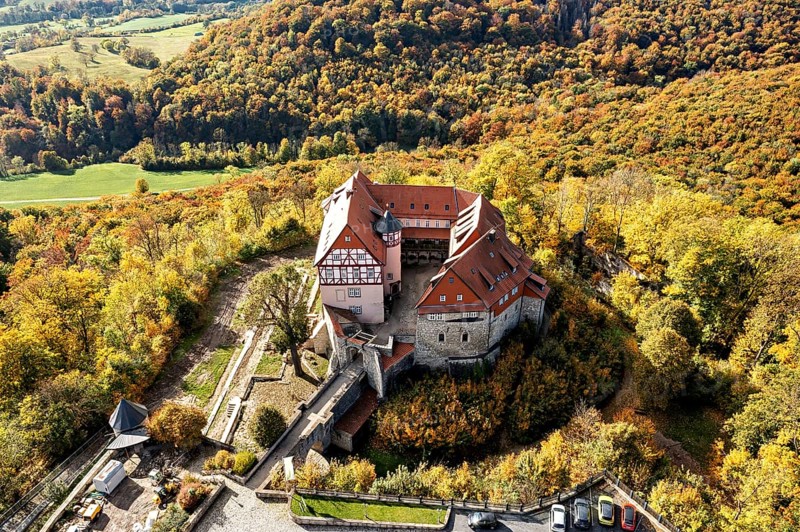 Historic castle surrounded by autumnal forest in a beautiful landscape taken from the air, Bodenstein Castle in the Eichsfeld district of Thuringia