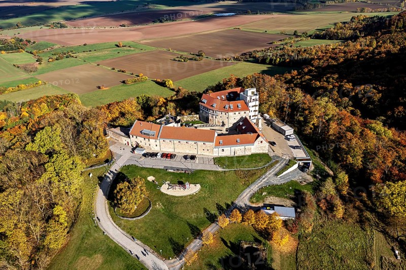 A castle on a hill with a bird's eye view of autumnal forests and fields, Schharfenstein Castle in the Eichsfeld district of Thuringia