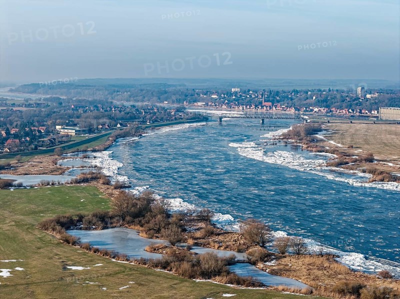 Icy riverbanks of the Elbe and ice in the foothills of the Elbe near Hohnstorf, Lüneburg district, on a cold winter day. In the background, the city of Lauenburg. aerial view. Hohnstorf, Lower Saxony, Germany