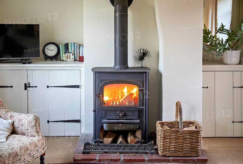 Logs burning in roaring fire of Clearview stove in domestic residential living room, UK