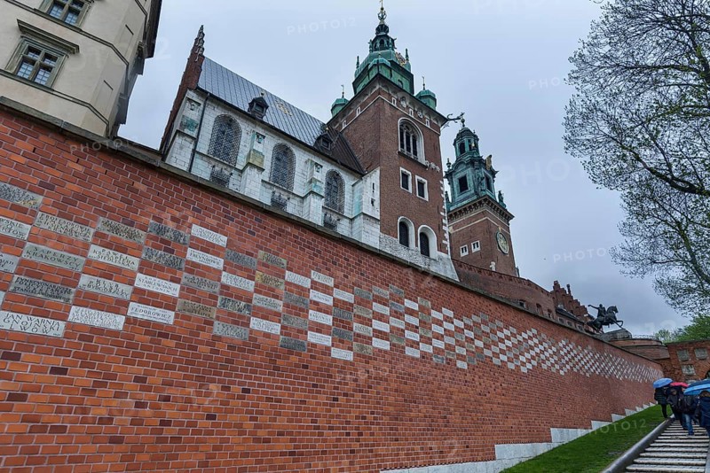 North façade of the cathedral on Wavelhügel, tourist group in the rain, Krakow, Poland