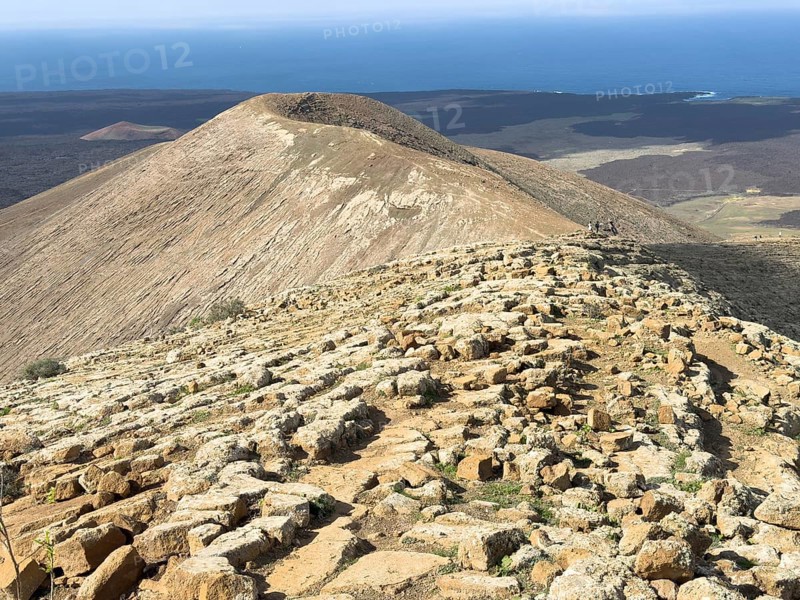 View from Caldera Blanca volcano against blue sky with white clouds, Mancha Blanca, Lanzarote, Canary Islands, Spain