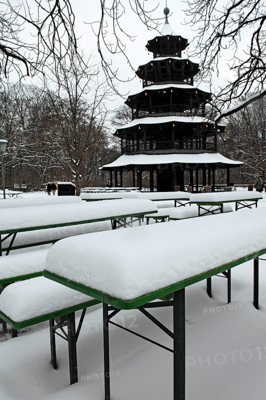 Winter in the English Garden, snow-covered beer garden tables and benches, Chinese Tower, Munich, Bavaria, Germany