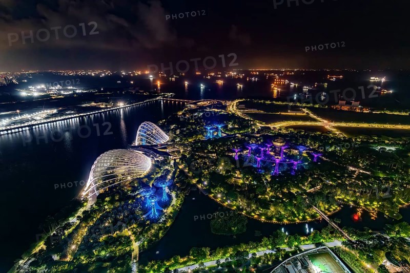 Aerial view over the illuminated Gardens by the Bay, GBTB and Supertree Grove, urban park and skyline of the city Singapore at night, Southeast Asia