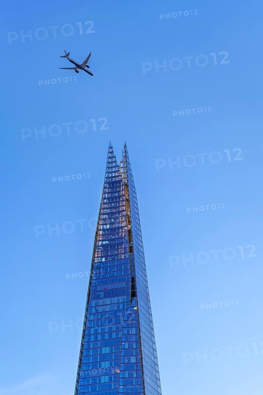 Airplane of British Airways flying over The Shard, skyscraper and tallest building in the United Kingdom in Southwark in the city London, England, UK
