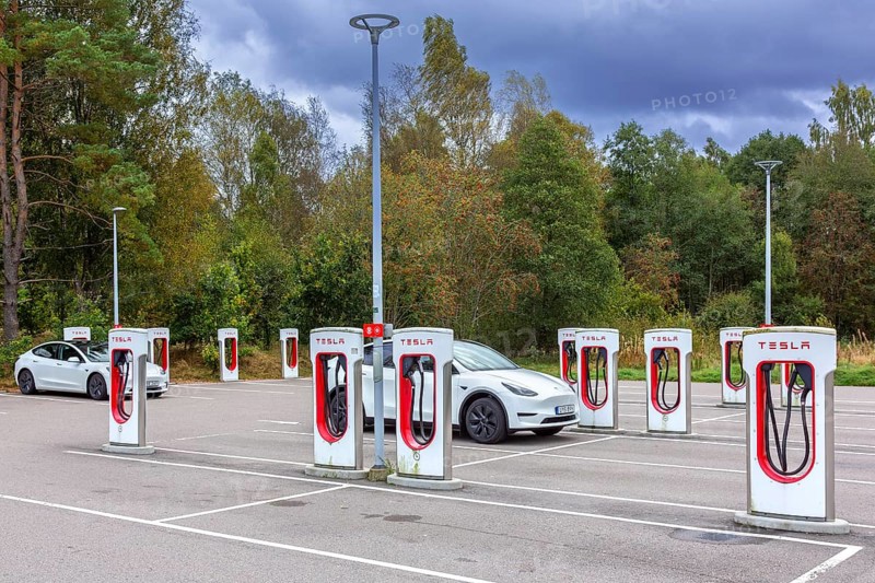 Parking area with public charging station / loading points from Tesla, network of rapid chargers for electric vehicles / cars in Sweden