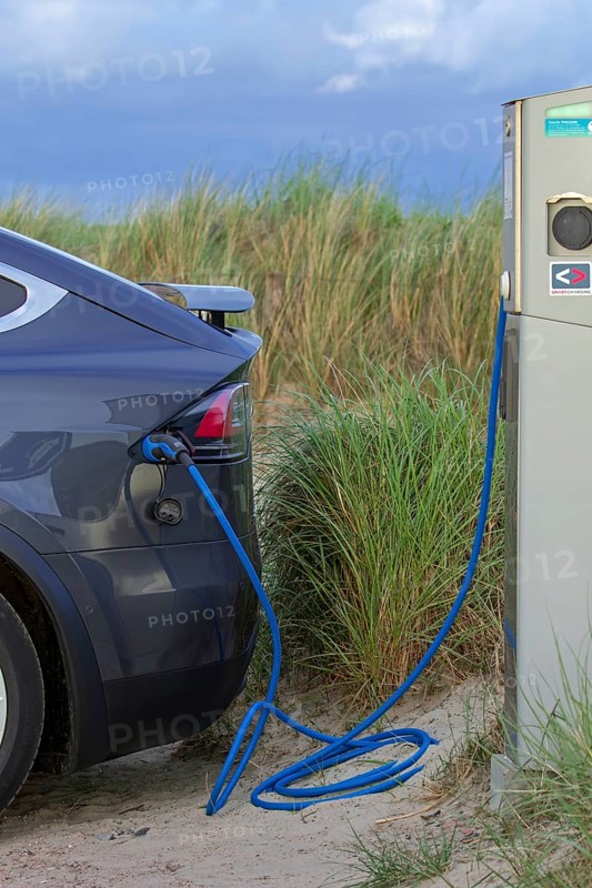 Electric vehicle / EV charging at public charging station / loading point for electric cars in the dunes on the island Texel, Netherlands