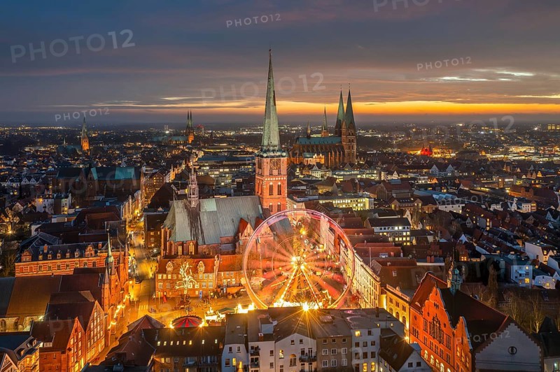 St. James' Church / Jakobikirche and illuminated Ferris wheel at evening Christmas market in winter at Koberg, Hanseatic city Lübeck, Germany