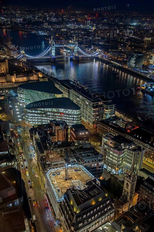 Aerial view from Sky Garden over Tower Bridge, the River Thames and illuminated highrise buildings in the capital city London at night, England, UK