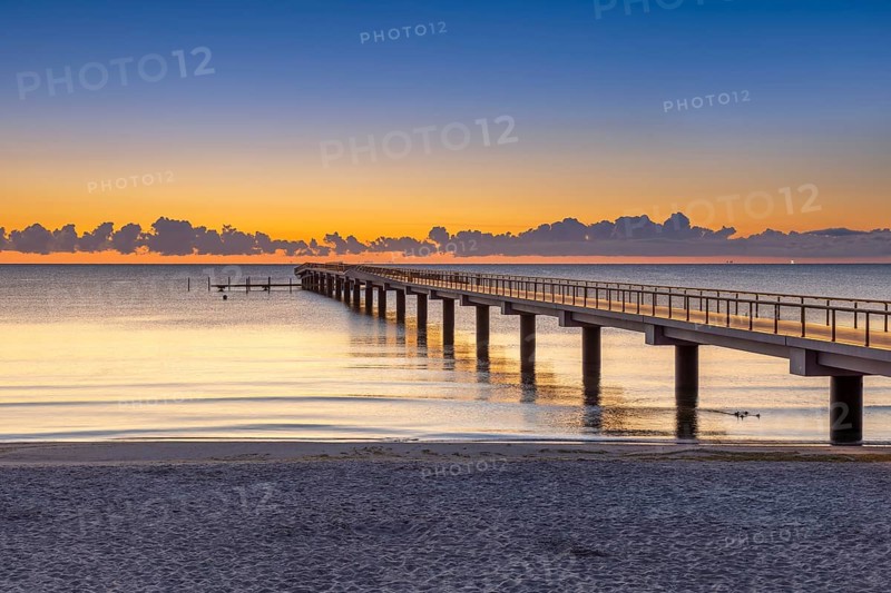 Seebrücke / pier and sandy beach at seaside resort Scharbeutz along the Baltic Sea at sunrise, Ostholstein, Schleswig-Holstein, Germany