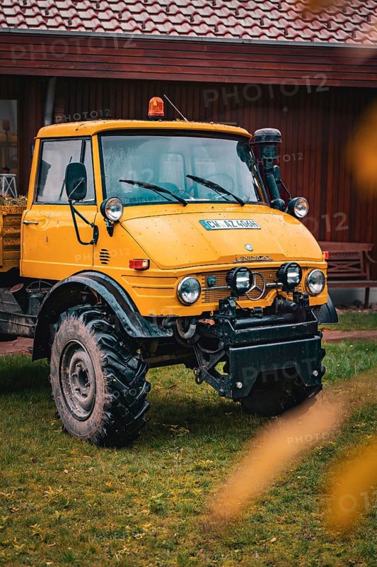 A yellow Unimog stands in the rain on a farm, tree work, Gechingen, Calw district, Germany