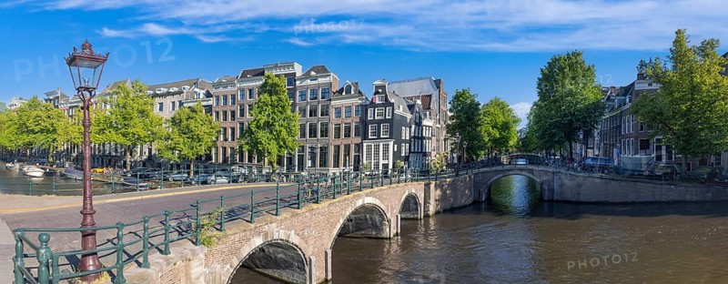 Holland, Amsterdam canals with boats, scenic bridges and historic city center, UNESCO World Heritage site