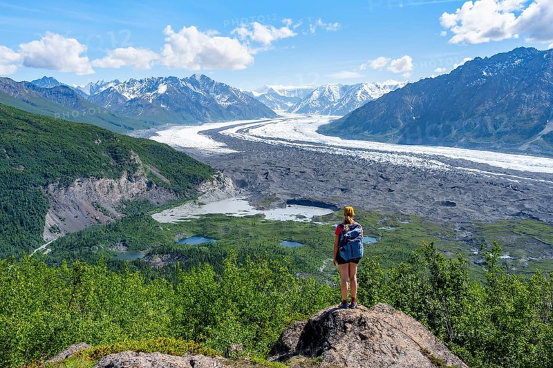 Young woman enjoying the view, view of impressive mountain landscape with Matanuska glacier and glaciated mountain peaks, Lion's Head, Chugach Mountains, Alaska