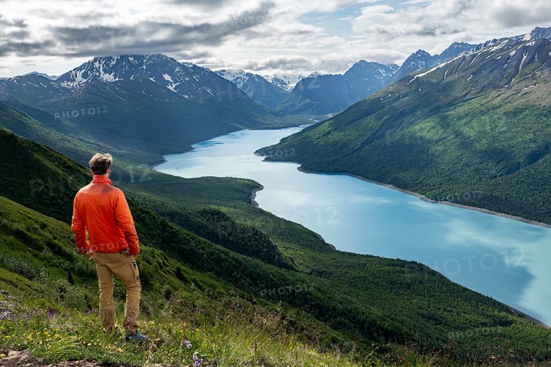 Mountaineer enjoys views of blue lake and mountains on Twin Peaks Trail, Eklutna Lake, Chugach Mountains, Chugach State Park, Alaska, USA