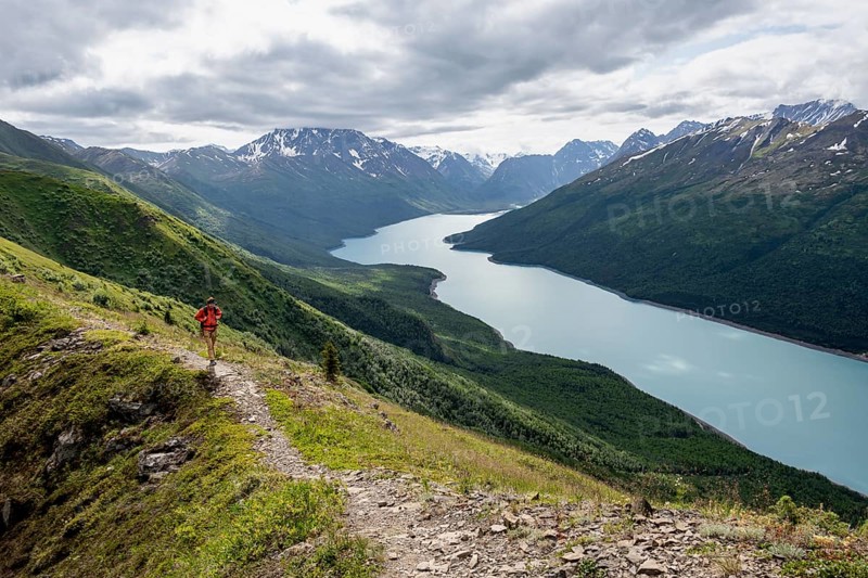 Climbers on a hiking trail, view of blue lake and mountains on Twin Peaks Trail, Eklutna Lake, Chugach Mountains, Chugach State Park, Alaska, USA