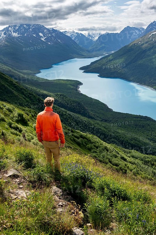 Mountaineer enjoys views of blue lake and mountains on Twin Peaks Trail, Eklutna Lake, Chugach Mountains, Chugach State Park, Alaska, USA