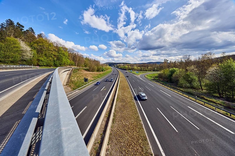 Hilly landscape, car bridges, motorway bridge, metal railings, road, motorway exit AS Bessenbach Waldaschaff, lanes, guide post, guardrail, medium green, forest, blue partly cloudy sky, cumulus clouds, cumulus congestus clouds, vehicles, A3 motorway, Bessenbach, Lower Franconia, Aschaffenburg district, Bavaria, Germany