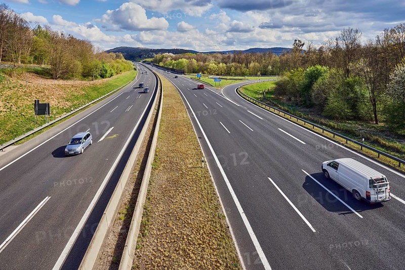 Hilly landscape, motorway exit AS Bessenbach Waldaschaff, lanes, guide post, guardrail, medium green, forest, blue partly cloudy sky, cumulus clouds, cumulus congestus clouds, vehicles, A3 motorway, Bessenbach, Lower Franconia, Aschaffenburg district, Bavaria, Germany