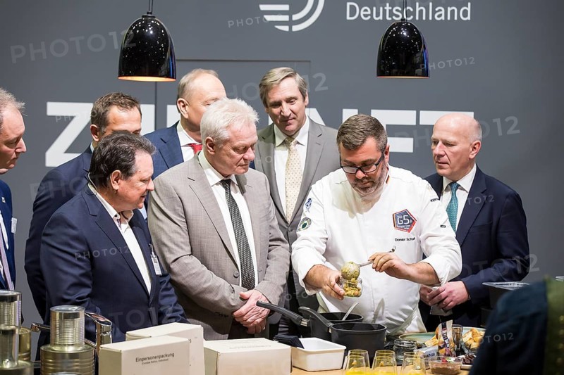 Christoph Minhoff (Managing Director of the Federation of German Food and Drink Industries), Alios Rainer (Federal Minister of Agriculture, Food and Home Affairs) and Kai Wegner (Governing Mayor of Berlin) preparing a currywurst from a one-person pack during the opening tour of the Green Week at the exhibition grounds in Berlin on 16 January 2026. The trade fair for the agricultural and food industry will take place from 16 to 25 January 2026