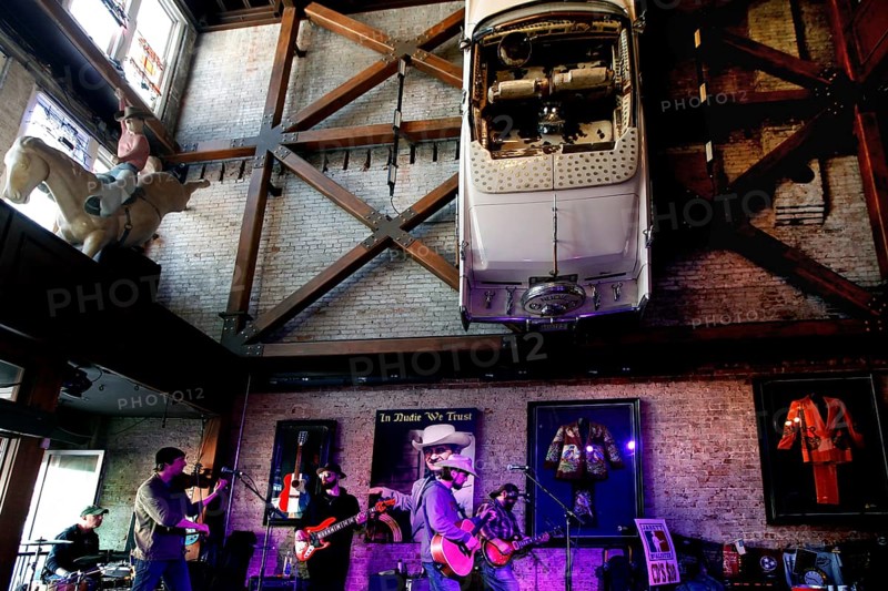 A band plays on a stage surrounded by retro industrial decoration with a car on the wall, Nashville, Tennessee, USA