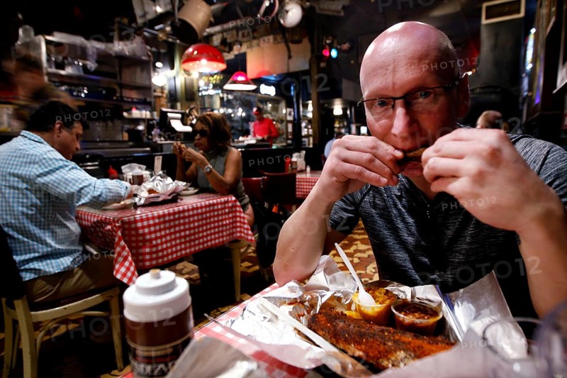 A man enjoys BBQ at Charlie Vegos' Rendezvous Restaurant in Memphis, Memphis, Tennessee, USA