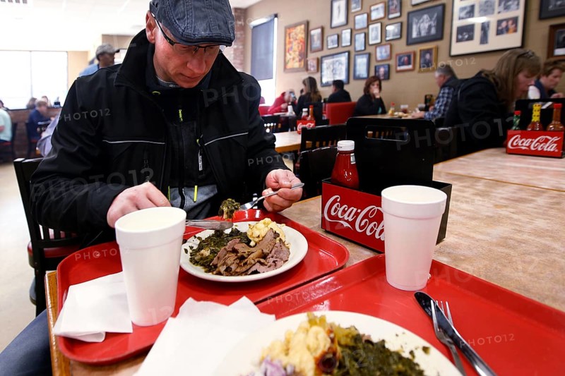 Person eating at a cozy restaurant with red trays, Nashville, Tennessee, USA