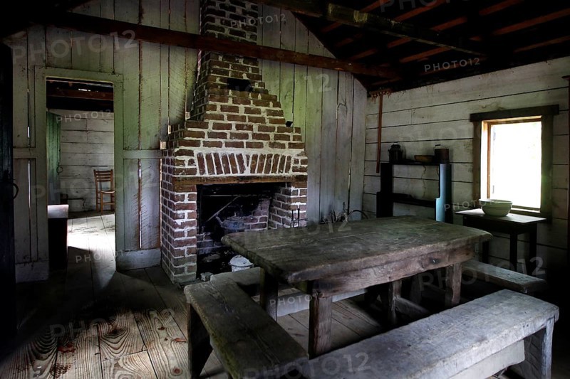 Rustic interior decor of a slave shelter with fireplace and table, Charleston, South Carolina, USA