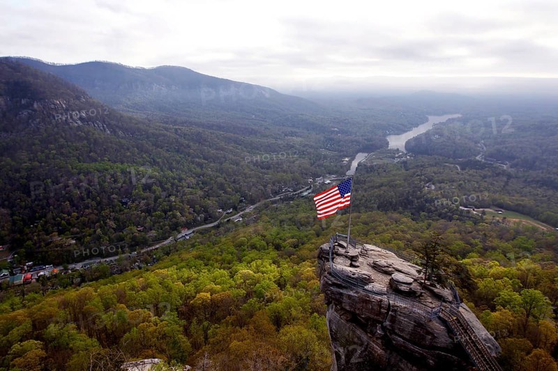 Majestic view of Chimney Rock with US flag and vast forests, zero