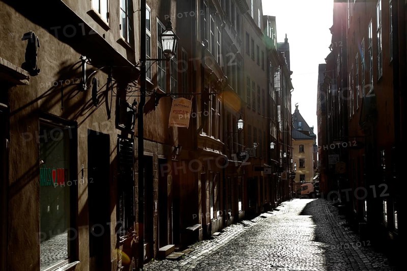 A shady old town alley in the historic old town of Stockholm, with paved paths and old buildings, Stockholm, Gamla Stan, Sweden