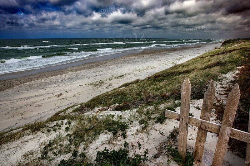 Baltic Sea beach with grassy dunes, a wooden fence and wild waves, Ephas Heights, Kaliningrad, Russia